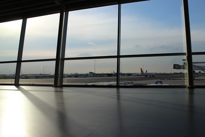 玻璃窗显示白天蓝天下的飞机和跑道